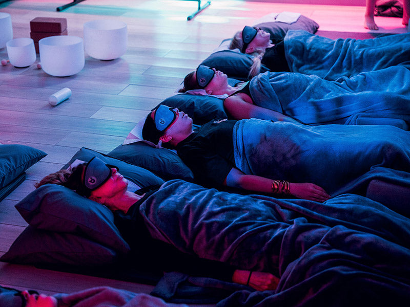 A group laying on the floor during a breathwork class at breathe degrees